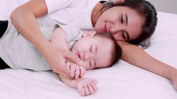 A young mom and her baby sleeping and sweet dream together. video