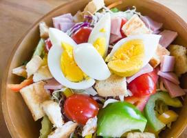 Closeup of the fresh organic salad with ham and boiled egg. photo