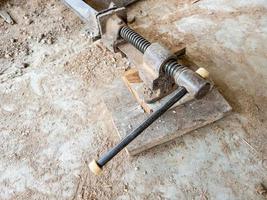 The old clamps tool on the dirty ground for use in the small site. photo