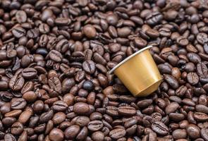 Modern coffee capsule on the roasted coffee bean. photo