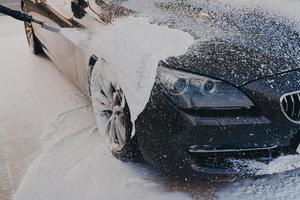 Vehicle cleaning with high pressure foam gun photo