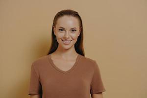 Natural beauty. Young charming woman with daily makeup wearing basic beige t-shirt smiling at camera photo