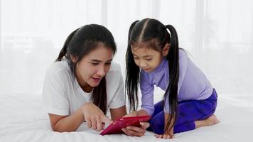 gelukkige moeder en dochter met behulp van digitale tablet, online videogames spelen, plezier maken op internet. video