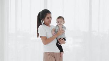 Asian Mother take care her baby after waking up. Single mom family concept video