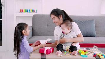 feliz concepto de familia y día de la madre, hija, madre y bebé disfrutan juntos. video