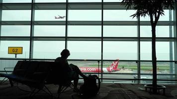 vrouw wacht op stoel in gate-terminal voor vertrek van de vlucht video
