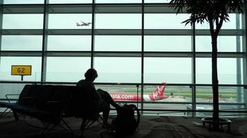 le donne stanno aspettando sul posto al terminal del gate per la partenza del volo video