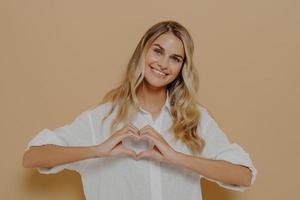 mujer rubia haciendo forma de corazón con sus manos foto