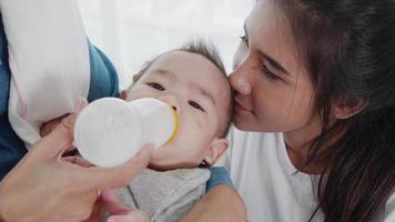 The baby drinks from a bottle of milk. video