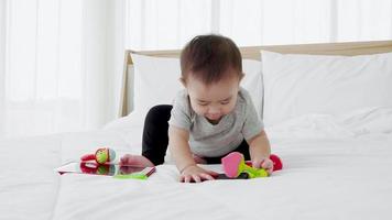 gelukkige familie schattige baby speel speelgoed op bed. kleuterschool voorschoolse educatie video