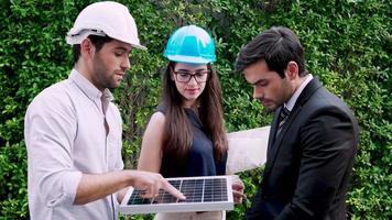 tres ingenieros de plantas de energía solar de pie y discutiendo el proyecto del panel solar juntos