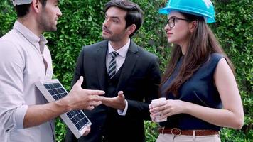 Three engineer in uniform discussing Solar cell farm. Concept of green energy video