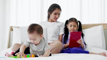 Busy mother with two daughters multitasking with laptop, Super mom concept video