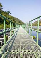 Long metal bridge is floating on the reservoir. photo