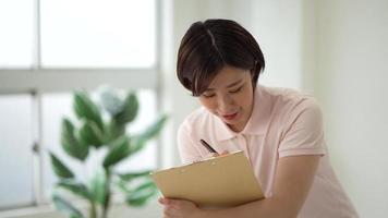Image of a caregiver holding a binder and asking questions video