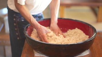 uomini che aggiungono acqua alla farina di grano saraceno e mescolano video