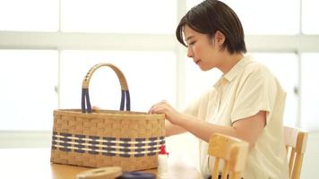 A woman making a basket with a craft band