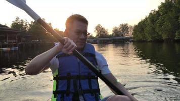 asiatisk man paddla kajak i kanalen under sommarlovet video