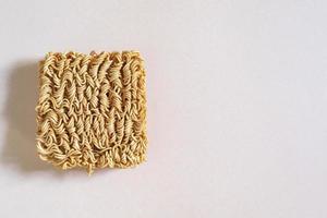 aislado de fideos instantáneos de comida asiática en una mesa de madera rosa. foto