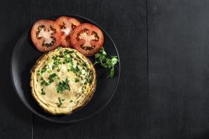 Egg breakfast food omelet has vegetable in plate on wood table. photo