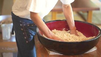 uomini che aggiungono acqua alla farina di grano saraceno e mescolano video