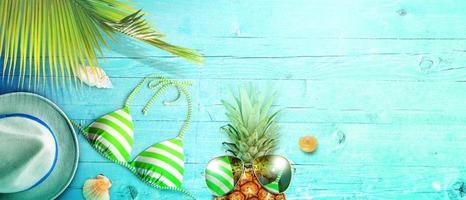 Nautical concept with palm leaf, beach hat, seashells and pineapple. photo