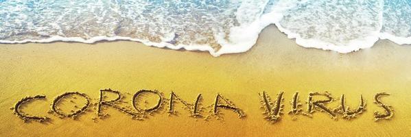 Corona virus written in the sand on vacation photo