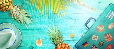 Nautical concept with palm leaf, beach hat, seashells and pineapple. photo