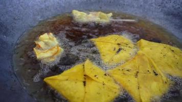 un comerciante está friendo comida frita para la venta video