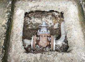 The old control valve is laying underground with the concrete border. photo