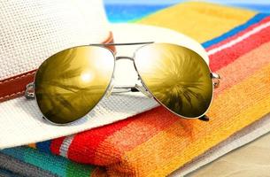 Summer tropical beach background with sunglasses and hat. photo