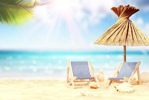 Relax on tropical beach in the sun on deck chairs under umbrella. photo