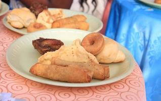 Close up of spring rolls, ring doughnut, fried chicken, meat pie and cup cake. photo