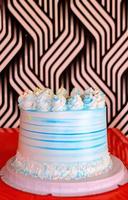 Side view of a Birthday cake decorated with white and blue icing. photo