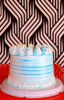 Side view of a Birthday cake decorated with white and blue icing. photo