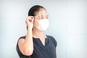 las mujeres asiáticas tienen que usar máscaras y protectores faciales para protegerse contra la contaminación del polvo y prevenir infecciones por secreciones que se esparcen en el aire foto