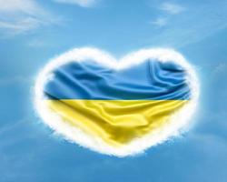 Ukraine flag in heart shape on blue sky photo