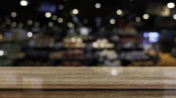 Empty wooden table top in front of abstract blur restaurant background. photo