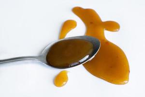 the drops of homemade sauce and a spoon on a white background photo