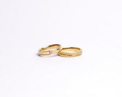 Jewelery ring with diamonds. Wedding rings that have deep meaning and significance. Engagement ring with gemstones. Wedding ring isolated on white background, focus blur. Pair in gold, silver, black. photo