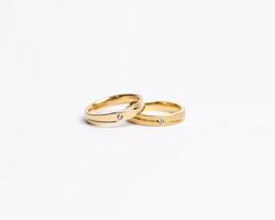 Jewelery ring with diamonds. Wedding rings that have deep meaning and significance. Engagement ring with gemstones. Wedding ring isolated on white background, focus blur. Pair in gold, silver, black. photo