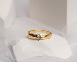 Wedding ring set on white stone. The jewelry ring is ready to be showcased and sold. The wedding ring is a sign of the love of the couple. Pearls and diamonds complete the ring's beauty. focus blur. photo
