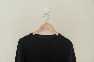 black sweater hanging on hanger photo