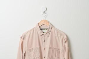 hanging shirt with wood hanger on wall photo