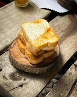 Slices of bread are lightly baked and stacked on wooden plates. Wooden background to add an aesthetic look. Can be used for backgrounds or advertisements. photo