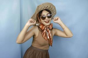 Young Asian confident and happy woman isolated by a blue background. photo