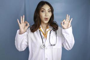 Young Asian woman doctor is smiling and showing OK sign. photo