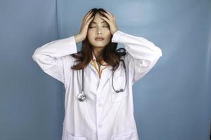 A portrait of a young Asian female doctor looks tired and overworked photo