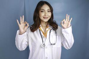 Young Asian woman doctor is smiling and showing OK sign. photo