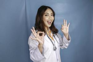 Young Asian woman doctor is smiling and showing OK sign. photo